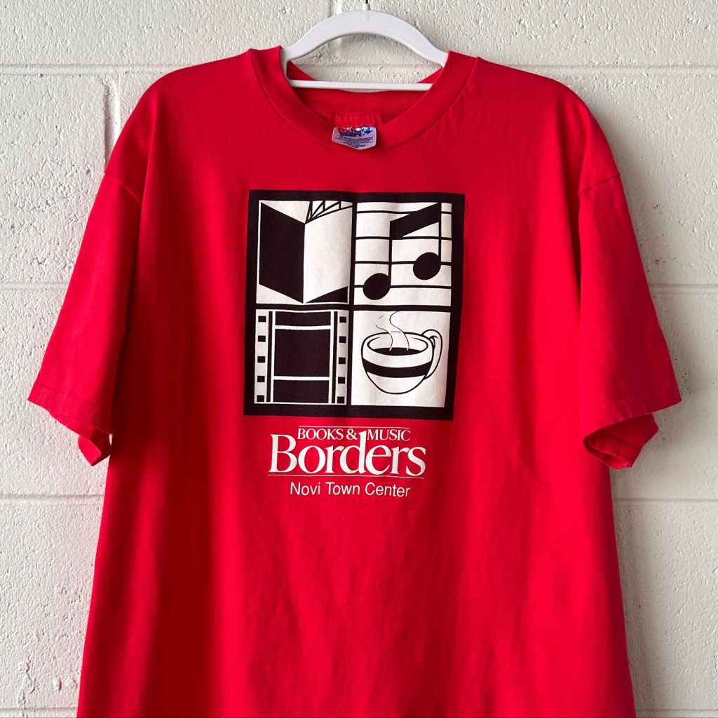a red t-shirt that shows little logos for books, music, film, and a coffee cup and says Borders in Novi Town Center