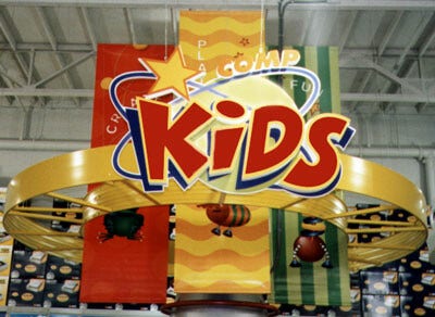 the kids section of CompUSA that has a sign saying Comp Kids and looks like a short and planet