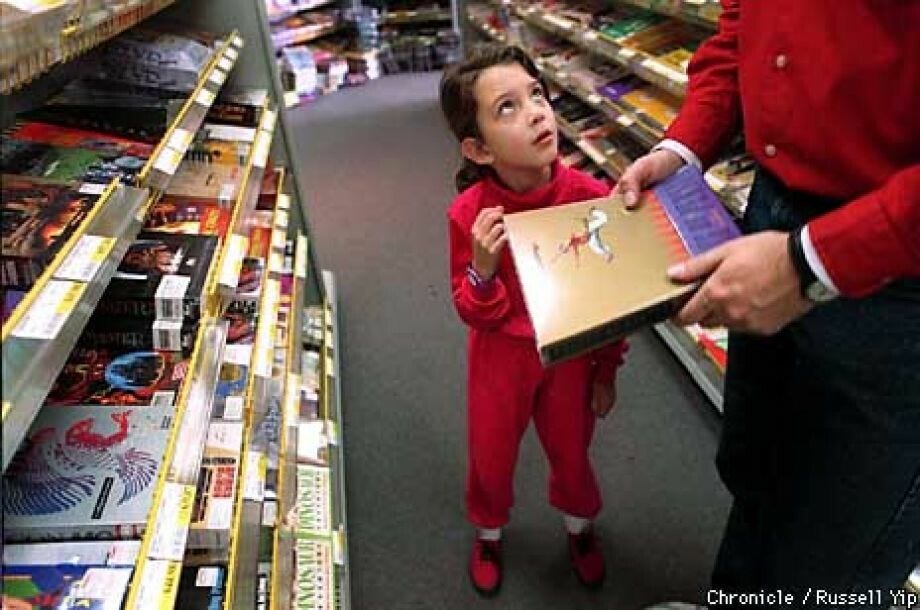 photo by Russell Yip of a little girl in an Egghead Software looking up at a parent who is holding Prince of Persia