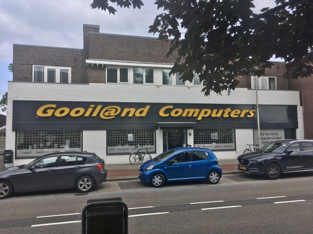 photo but closer from across the street of a white building that says "Gooil@nd Computers"