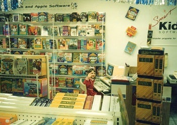 girl sitting at a computer in front of software boxes