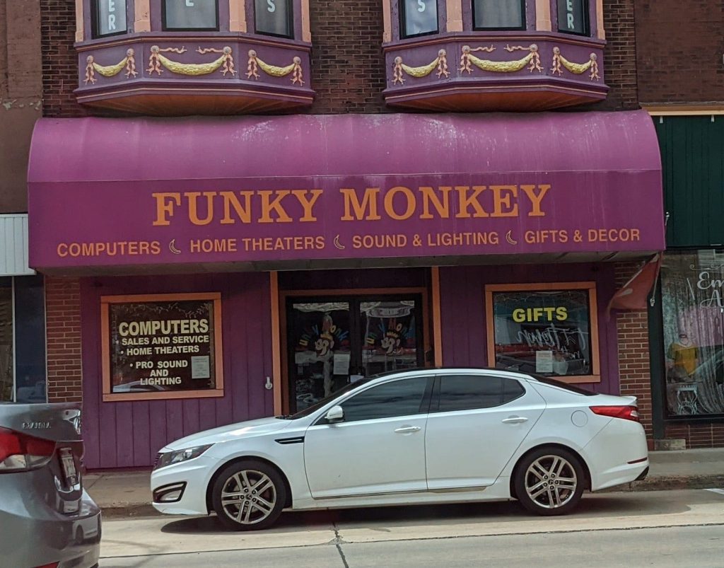 a purple building that says Funky Monkey - Computers, Home Theaters, Sound & Lighting, Gifts & Decor