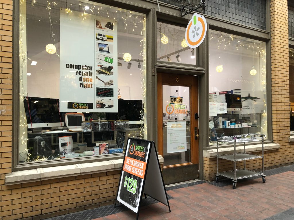 Front of store with various computers in the glass window in front