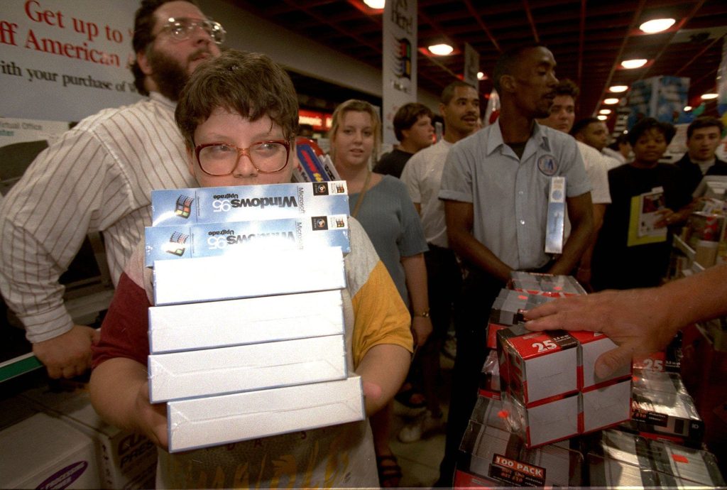 kid holding a stack of Windows 95 boxes