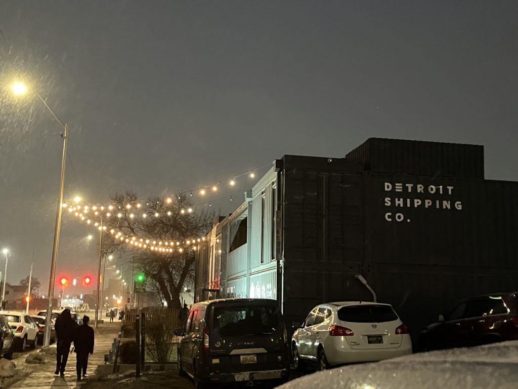 the outside of the Detroit Shipping Co. at night while it's snowing