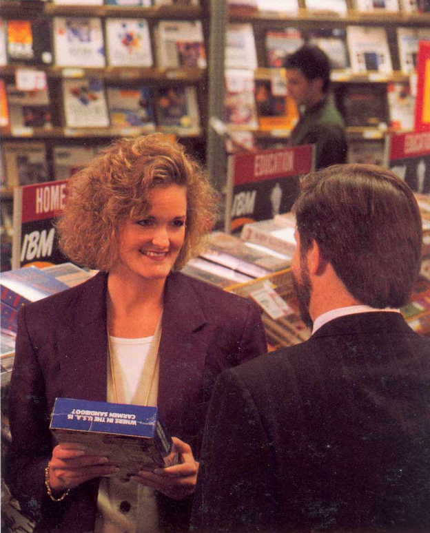 woman talking to a man while holding a Carmen Sandiego game